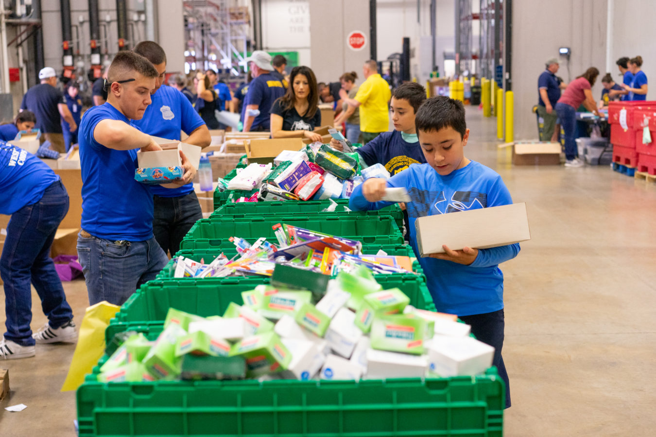 Blue Cares volunteers fill shoeboxes full of hygiene items for the annual United Way Shoebox Project