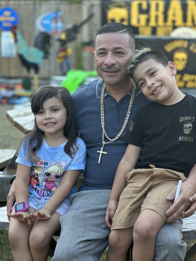 a man sits with his two small children